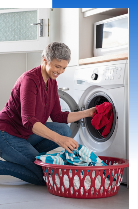 Woman pulling clothes from front loading laundry machine