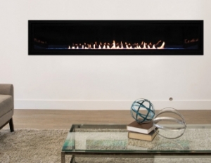 A long looking fireplace behind a glass coffee table
