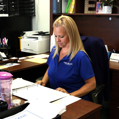 customer-service A woman sitting at a desk viewing papers