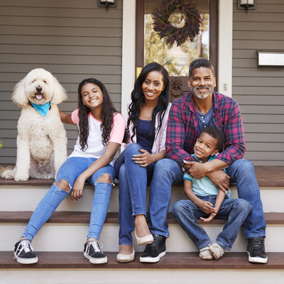 switch-and-save-with-thermotane A family and their dog sitting on the front porch