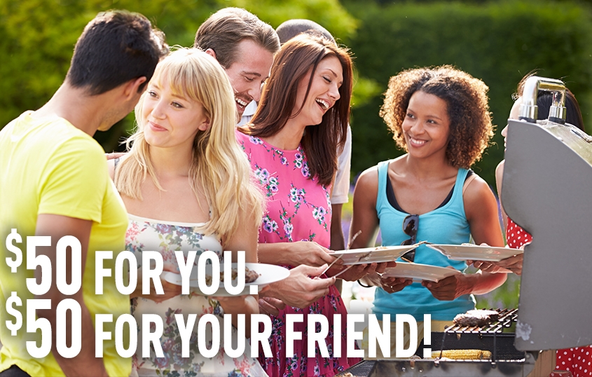Friends laughing in front of a grill