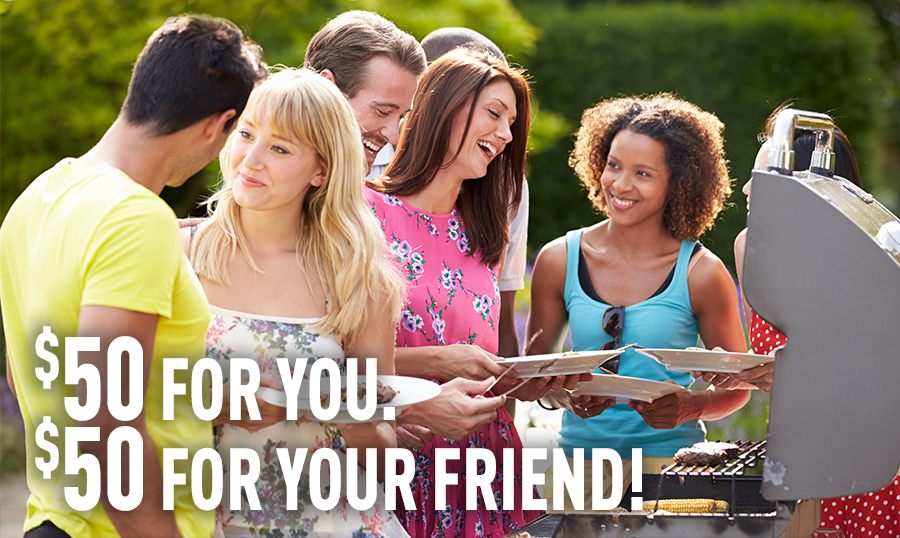 Friends laughing in front of a grill