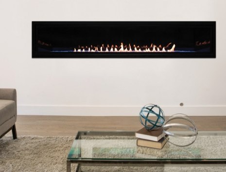 A long looking fireplace behind a glass coffee table
