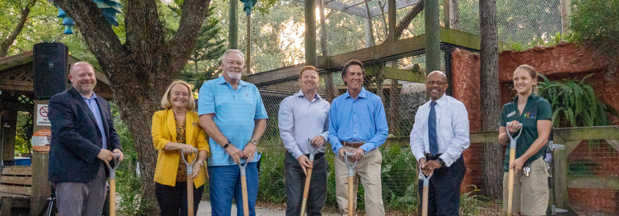 Seven individuals performing a ground breaking ceremony